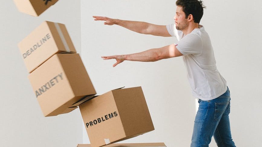 man falling carton boxes with negative words