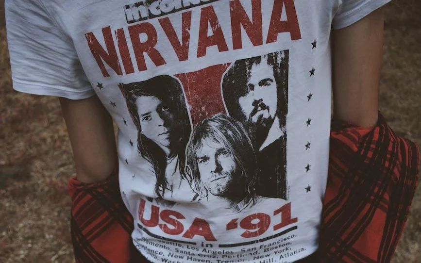 person wearing white and red nirvana top